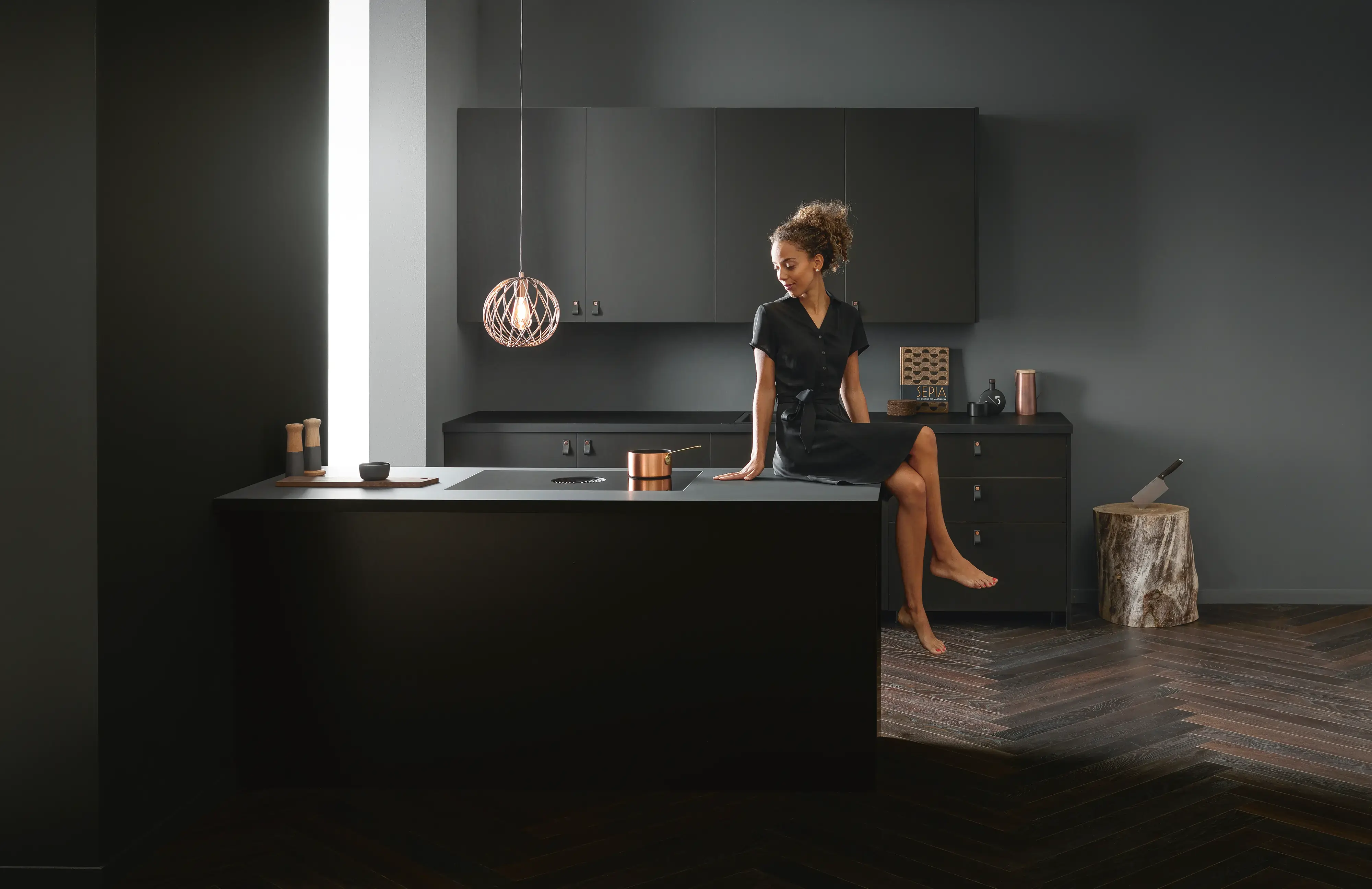 Open-plan kitchen with a BORA cooktop set into a dark kitchen island
